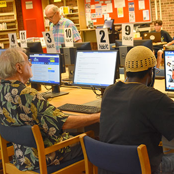 Various patrons using public computers at the library