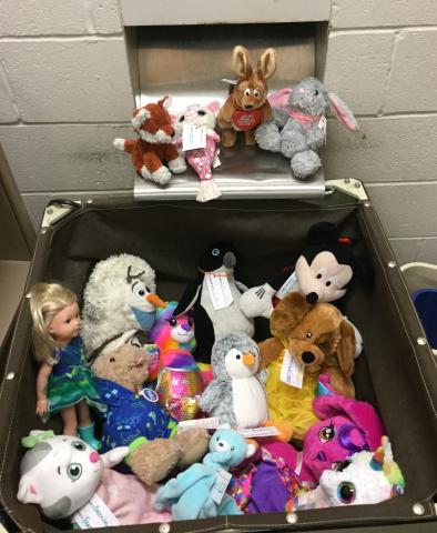 Stuffed animals sitting in a book drop bin
