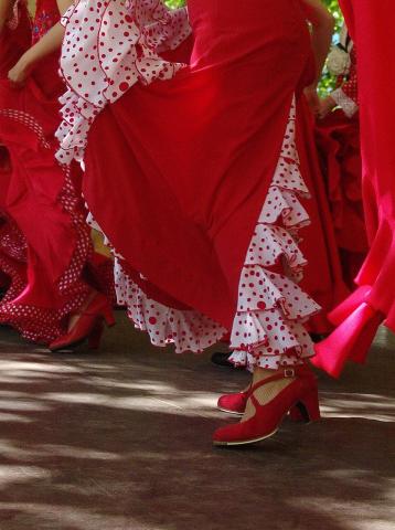 An image of flamenco dancers in bright red dresses and shoes. 