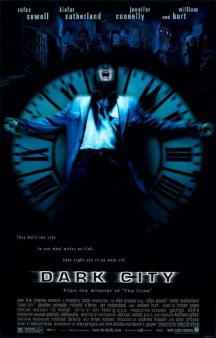 Poster for Dark City. Actor Rufus Sewell screams as he is strapped to a giant clock face that is roughly the same height as him. The rest of the image is completely black except for city buildings that appear blue above him.