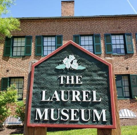 Photograph of the front of the Laurel Museum with its sign prominent in the foreground.