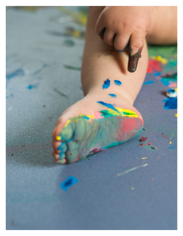 Photograph of a baby's foot where baby has stepped into wet paint.