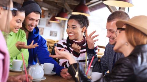 A group of adults socializing and having tea