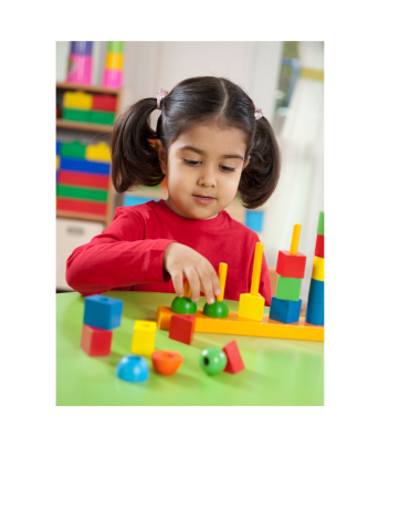 Preschool age girl with black pigtails and wearing a read shirt plays with primary colored blocks