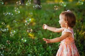 Young child playing with bubbles
