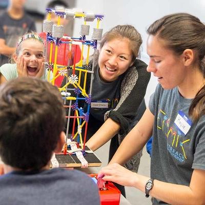 A group of teens building a structure out of K'NEX.
