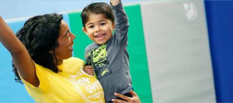 Adult holding a child, looking happy and excited