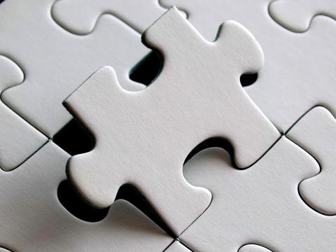 An image of a white puzzle piece about to fall into its place. 