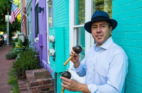 Man hold maracas and is wearing a hat