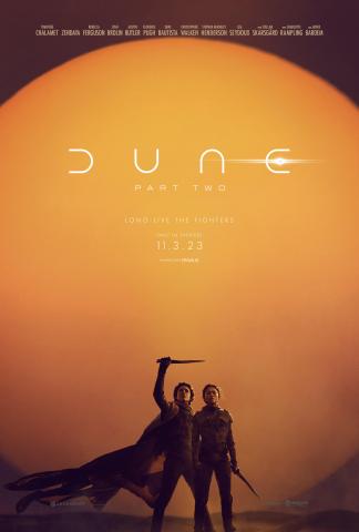 Paul Atreides holds a crysknife above his head with his right hand as he stands next to Chani in the desert on Arrakis. The Title of "Dune: Part Two" is written above them.