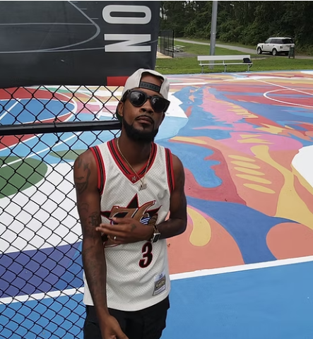 Photograph of Comacell Brown, and background mural on court.