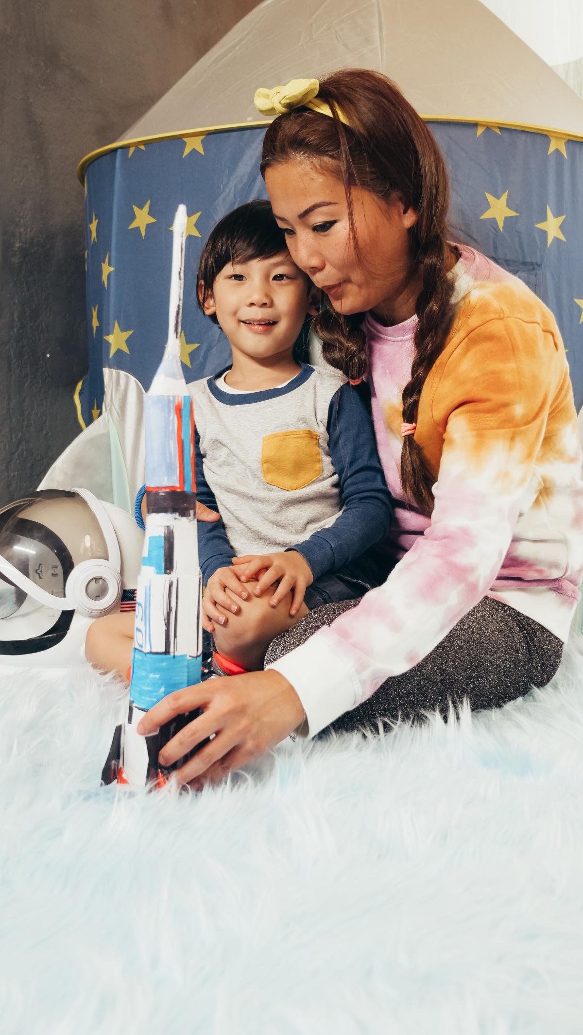 Child and adult playing with homemade toy rocket