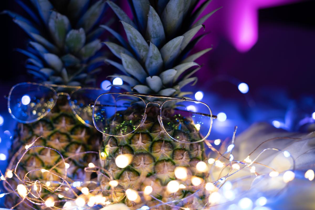 Two festive pineapples surrounded by twinkling lights.