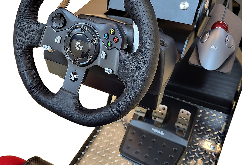 A close-up of the wheel, mouse, and pedals of a driving simulator.