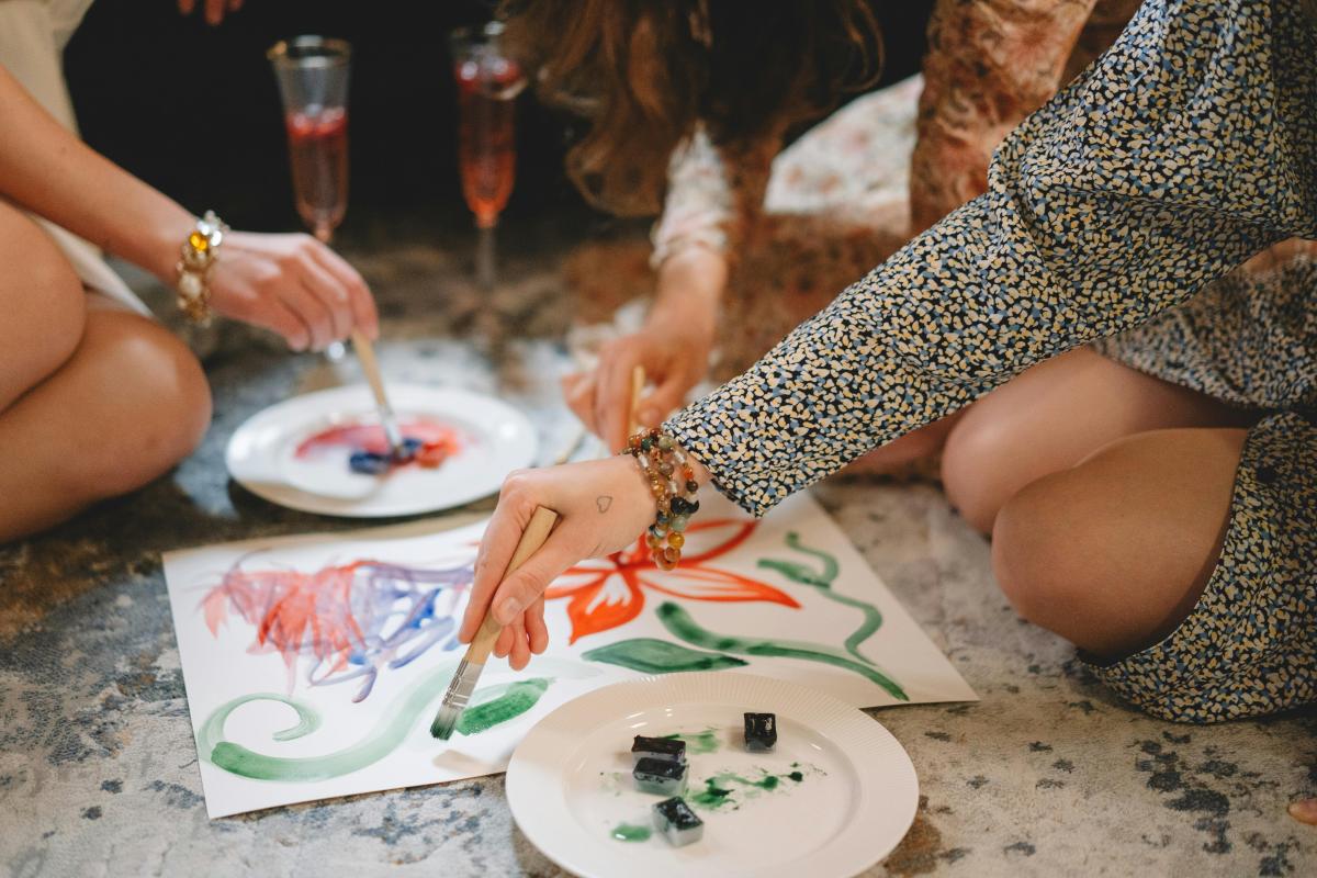 An image of several women painting and drinking tasty beverages.