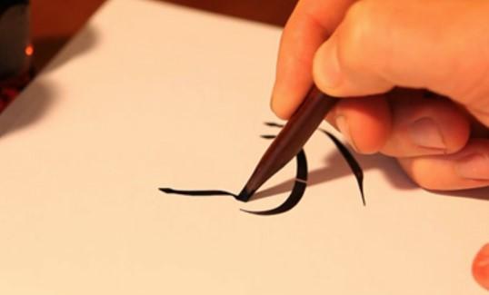 hand holding pen writting calligraphy