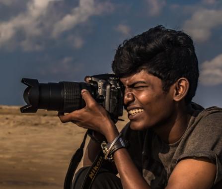 closeup of man outdoors taking a photo using a camera 