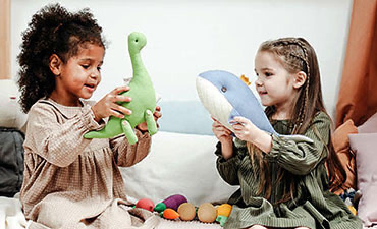 Two young children playing with stuffed animals