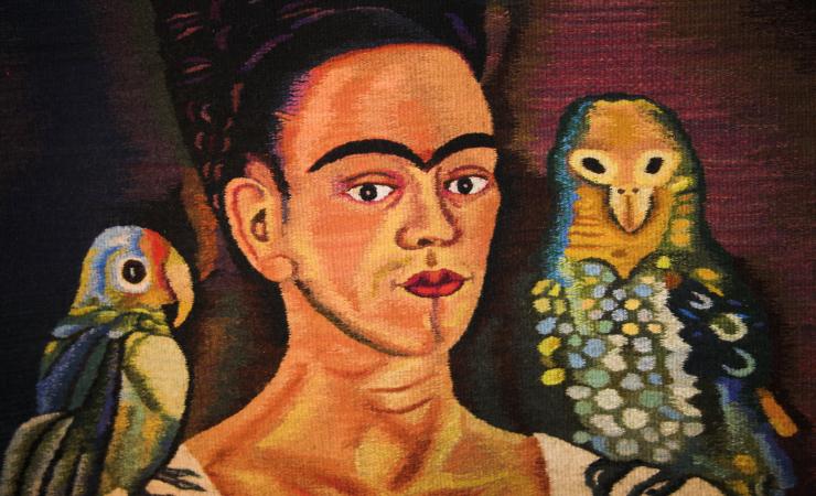 Frida Kahlo image with two colorful birds on each shoulder.